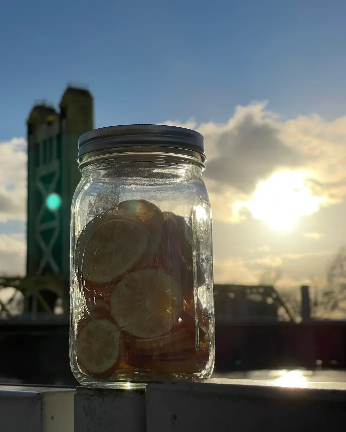 freeze dried lemons slices in a glass Mason jar in front of Sacramento's Tower Bridge